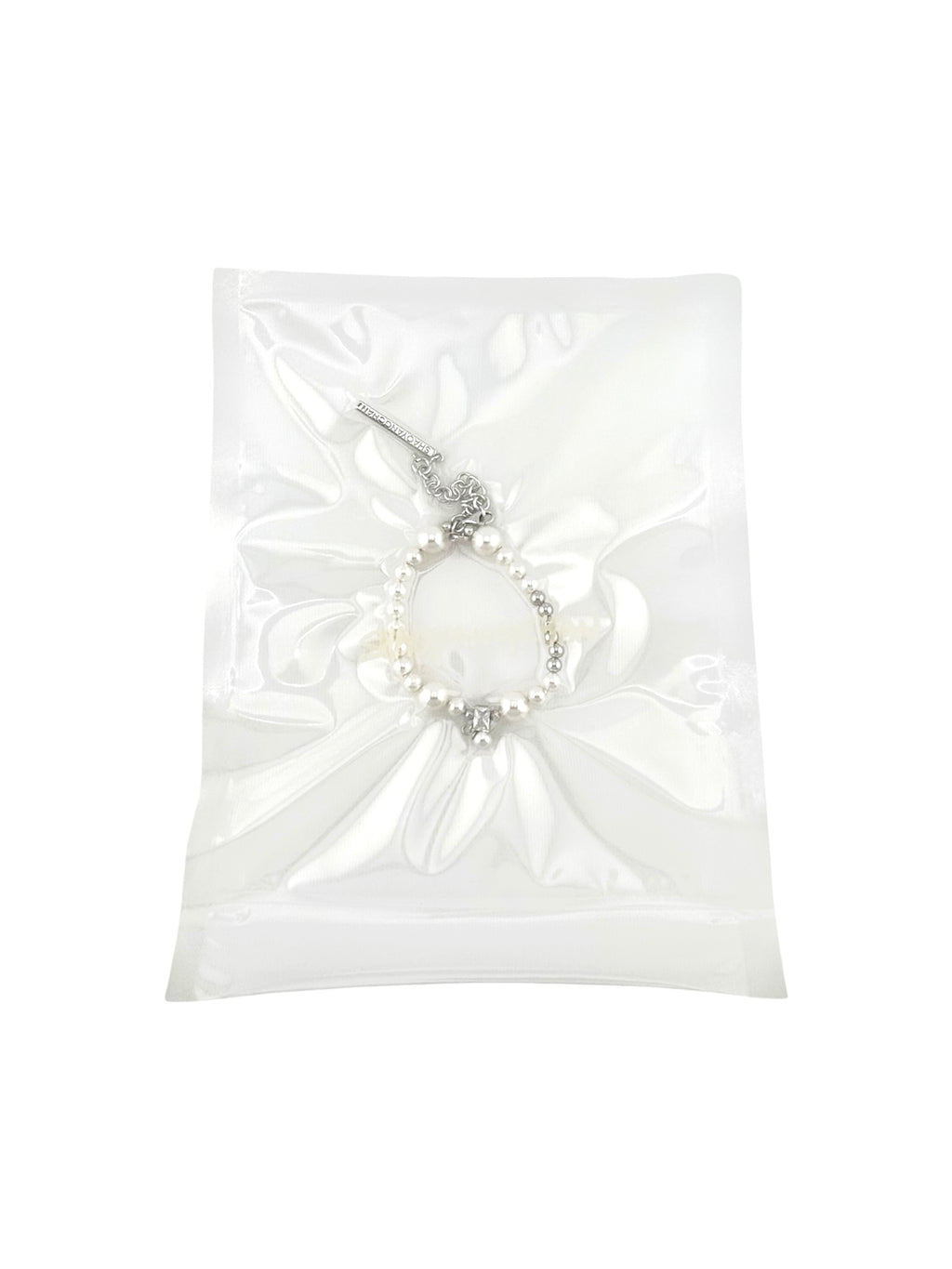 A silver and pearl bracelet in a clear plastic packaging.