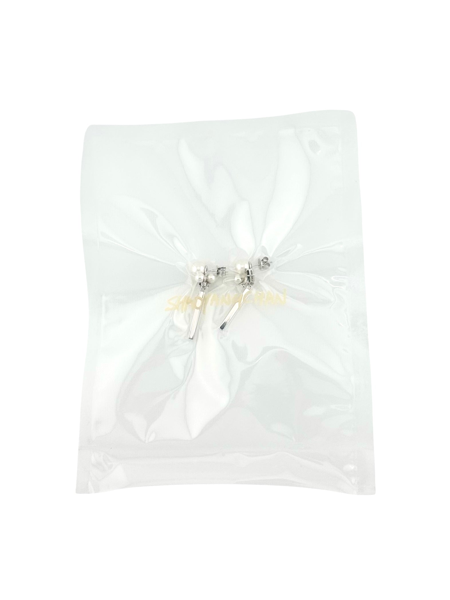 A pair of silver and pearl earrings packaged in a clear plastic bag.